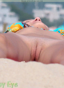 Shaved nudist pussy laying on the beach