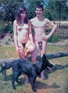 Nudist teen boy and girl are walking with the dog in the forest
