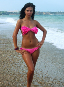 Sexy girl in black bikini laying on the sand near the sea