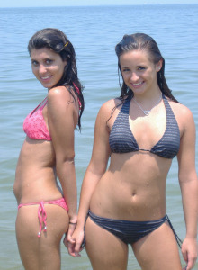 Exciting young girls in bikini playing in the water