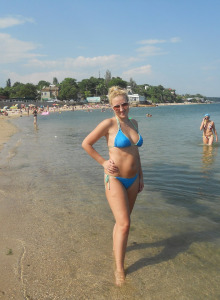 Doggy beach brunette girl in sunglasses and black bikini