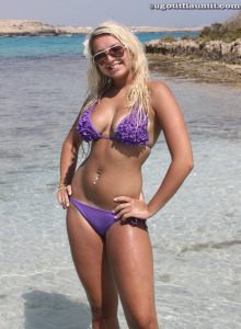 Busty blonde beauty in the sea with the purple bikini on