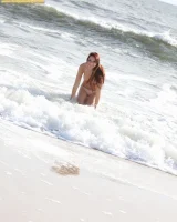 Exciting brunette Annabelle in black g-string micro bikini is swimming nude in the sea