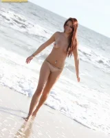 Exciting brunette Annabelle in black g-string micro bikini is swimming nude in the sea